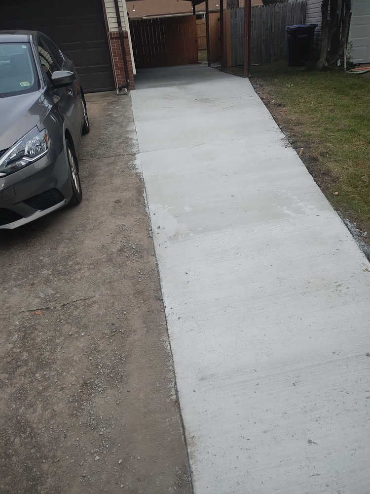 Concrete driveway extension beside a garage