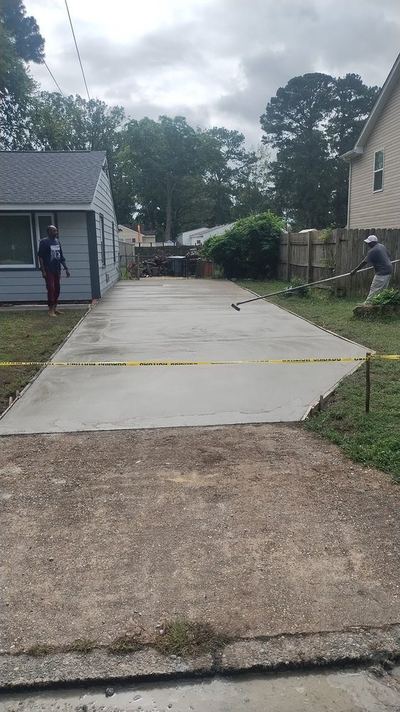 Workers finishing a new concrete driveway