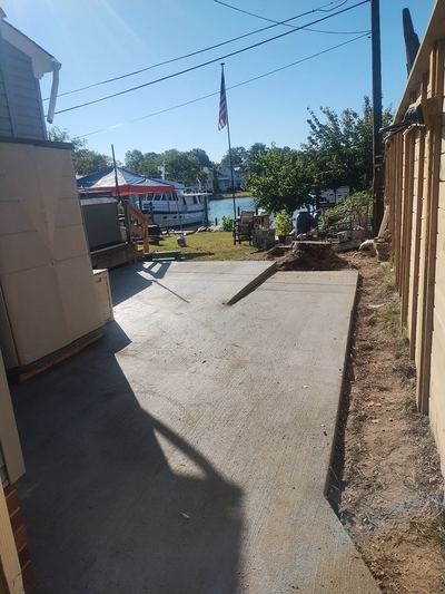 Concrete side yard slab running toward the water